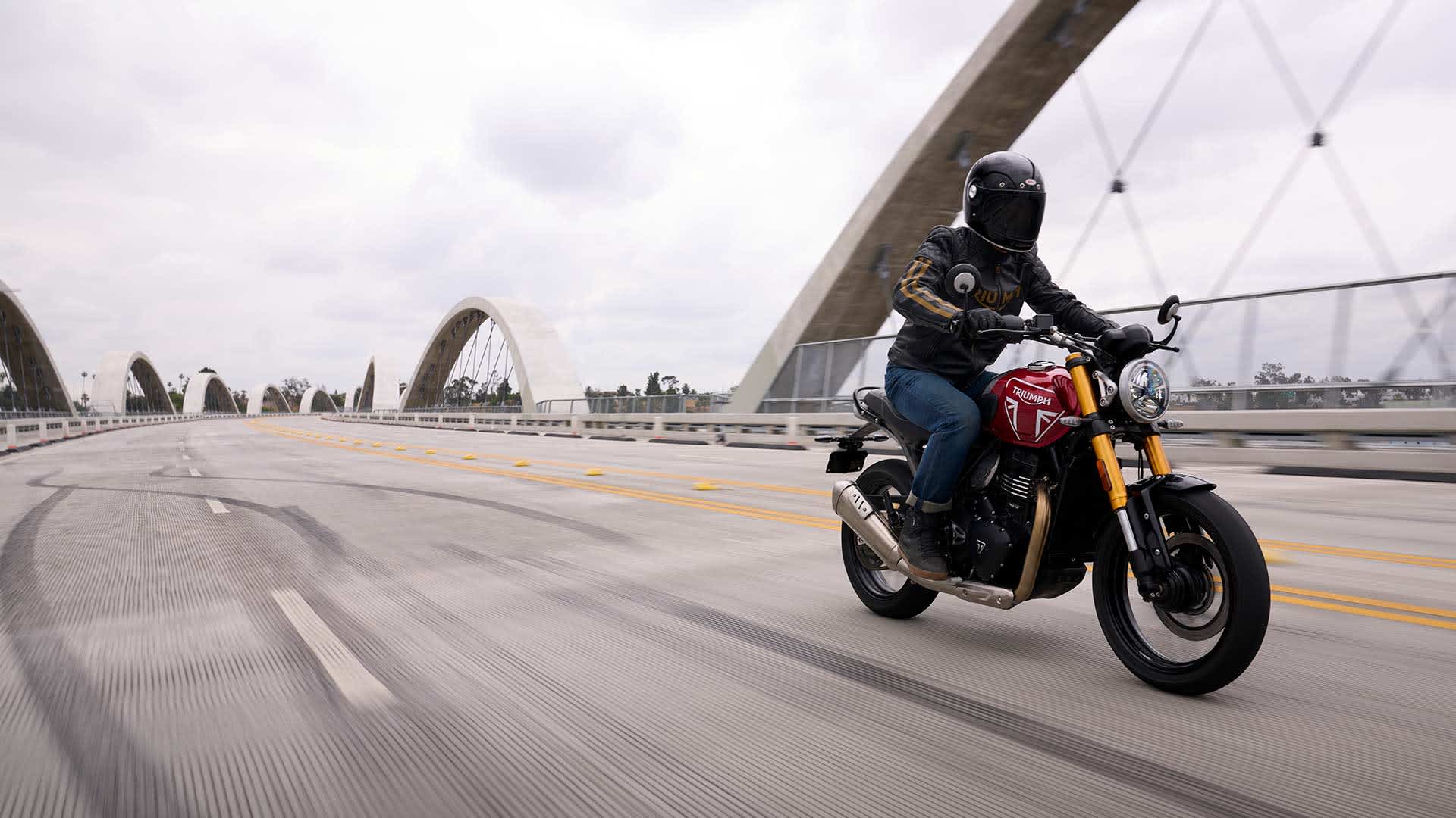 A rider on a Triumph Speed 400 crossing a bridge